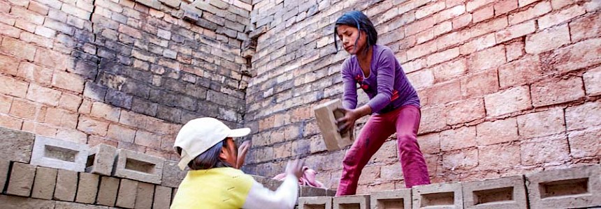 Zusammen mit ihrer Freundin schichtet Margarita die schweren Ziegel.  Sie muss jeden Tag hart arbeiten, um ihre Familie zu unterstützen.