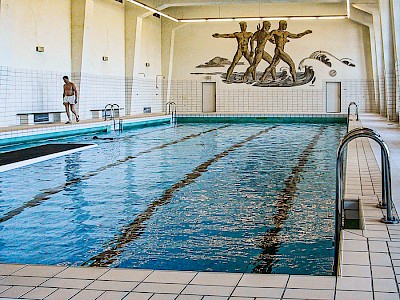 Das drei Meter hohe Wandmosaik erinnert an die dunkle Seite des Schwimmbades.