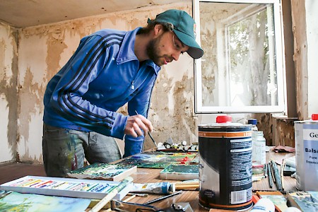 Kunststudent Julian Riedel holt sich die  Inspiration für seine Gemälde vor Ort.